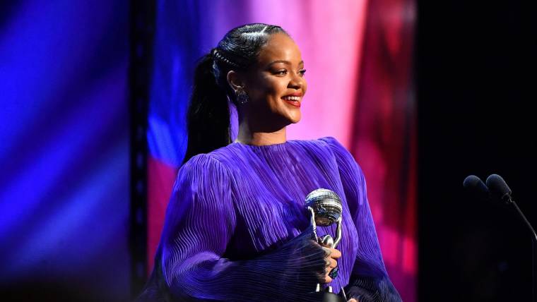 successful business woman Rihanna accepting an award on stage