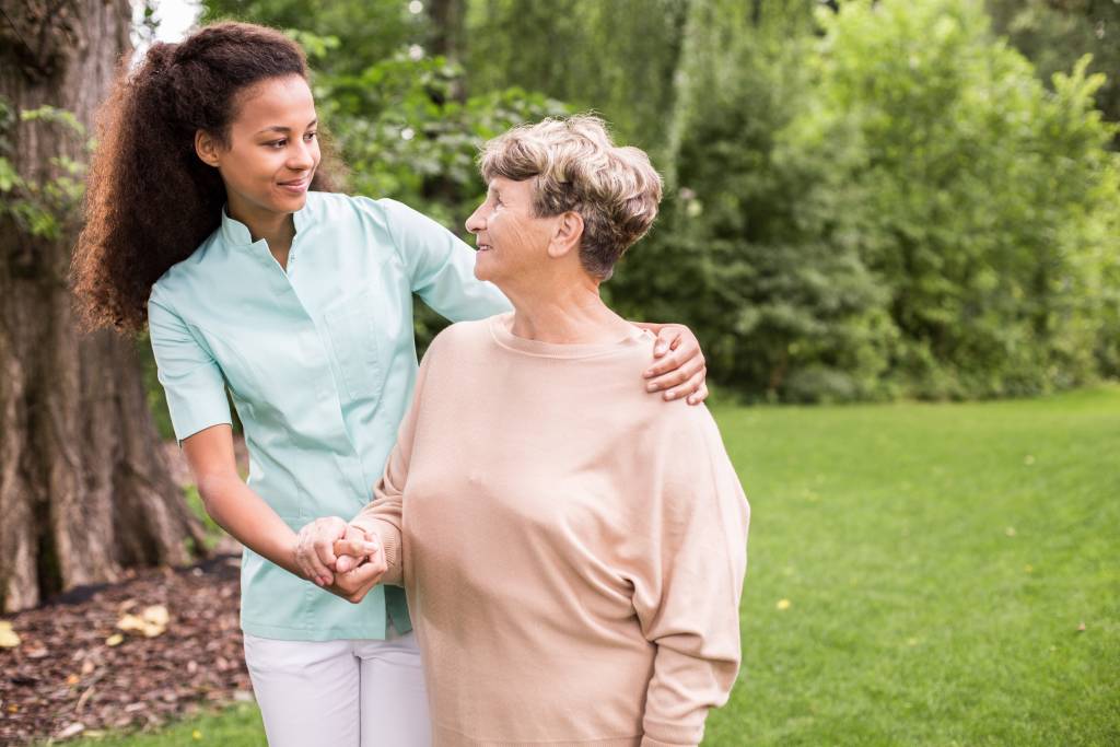 A caregiver and senior walk together