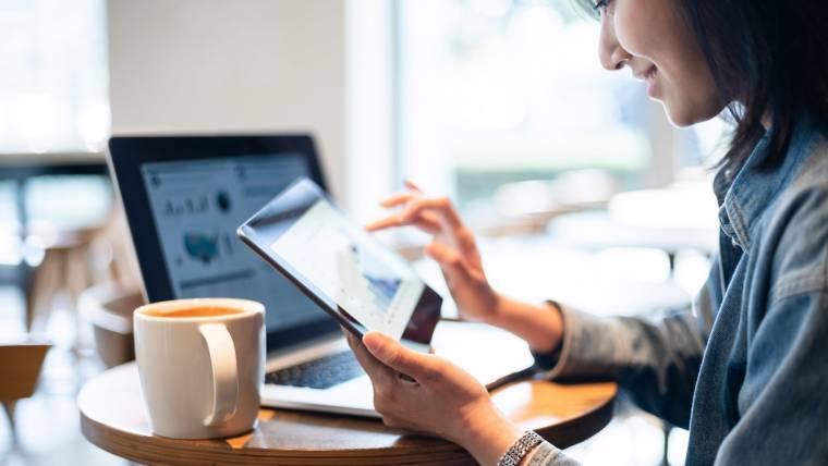 Smiling woman looking at data on a tablet