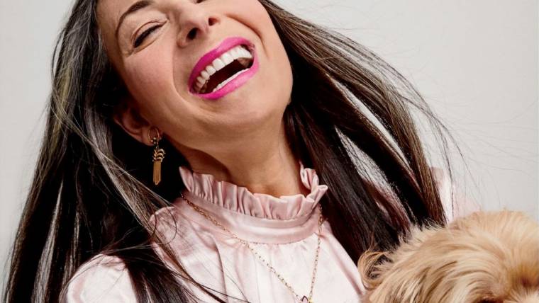 Entrepreneur Stacy London laughs while holding a dog