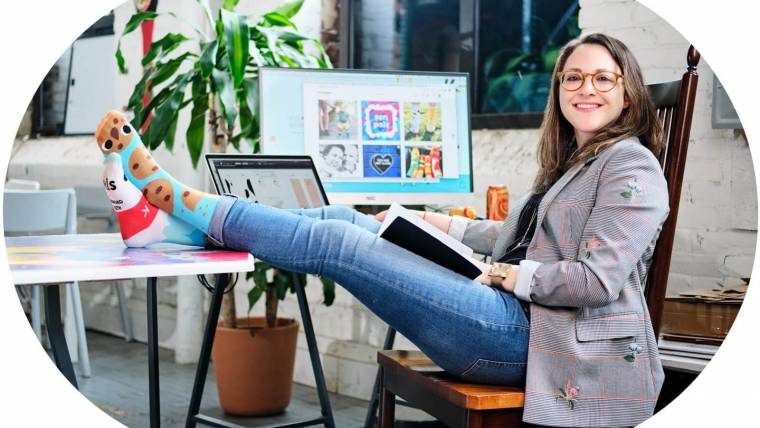 Pals Socks founder Hannah Lavon poses with her socked feet up on a desk