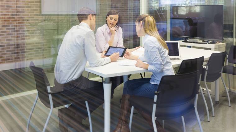 Three workers sitting around a conference table