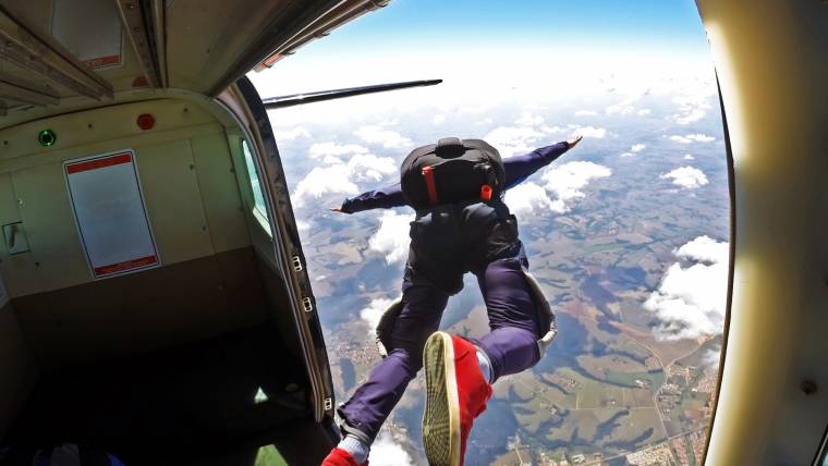 A skydiver jumps headfirst out of a plane