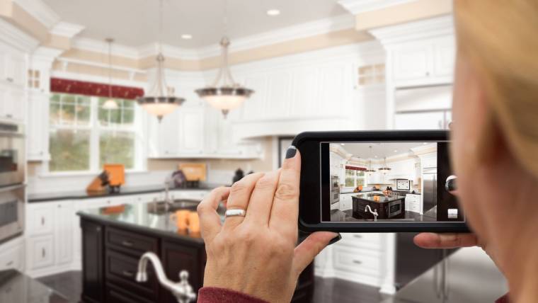 A woman produces a real estate video by filming a kitchen