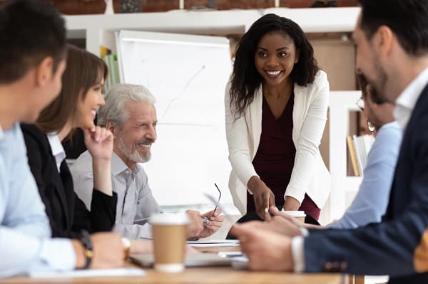 A diverse group of business people smile around a conference table