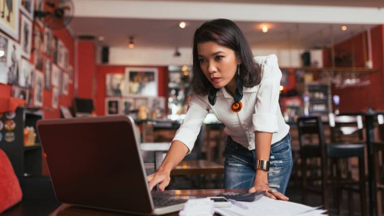 Woman works at her laptop in a restaurant