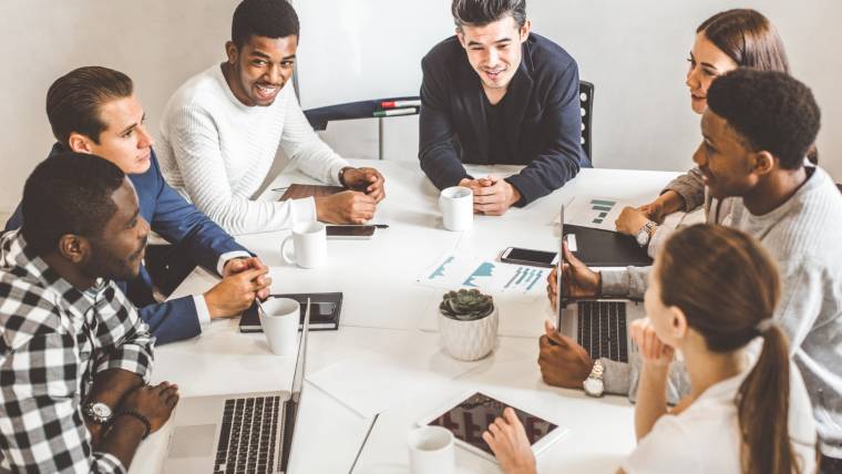 Colleagues talk at a conference table