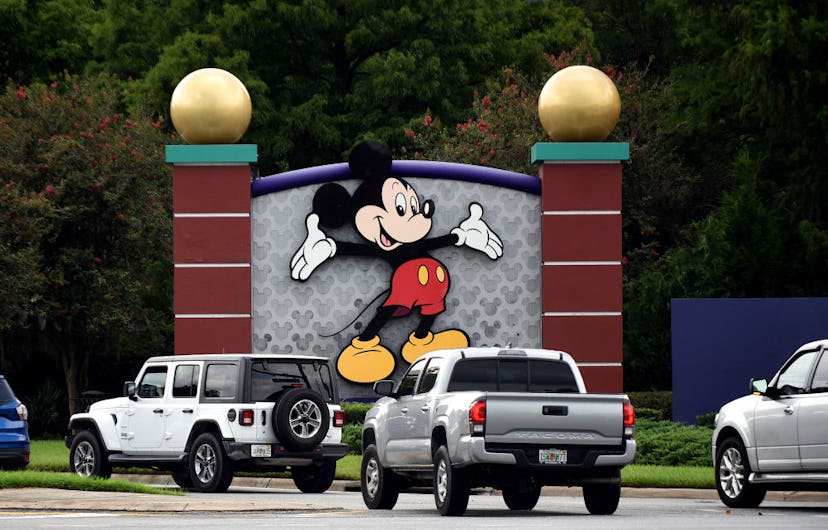 Cars drive past a sign featuring Mickey Mouse at the entrance to Walt Disney World on the day that p...