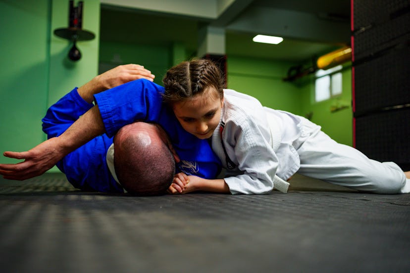 Little girl practicing Jiu-Jitsu with her coach, in a story about sports kids can start later in lif...